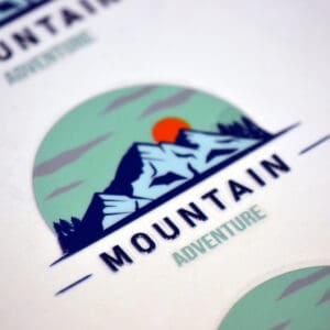 Mountain adventure logo with blue peaks.